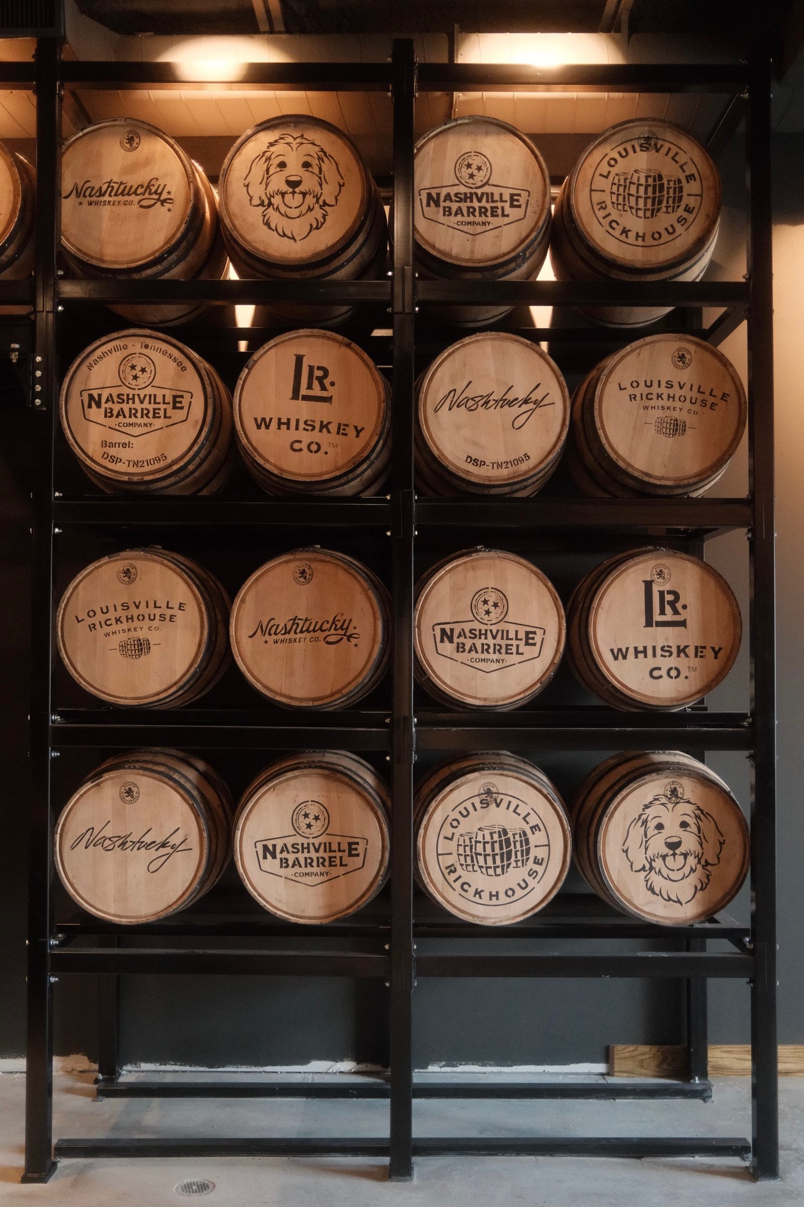 Branded Louisville Rickhouse, Nashville Barrel Co, and Nashtucky whiskey barrels racked in the NuLu rickhouse
