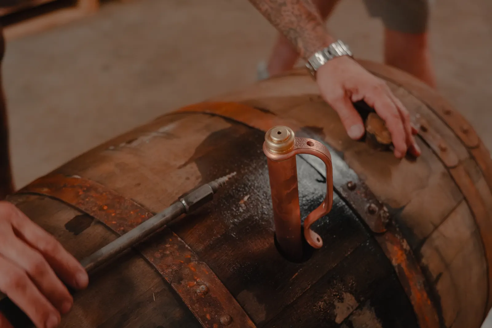 Copper whiskey thief set in the bung of an aging bourbon barrel at Louisville Rickhouse